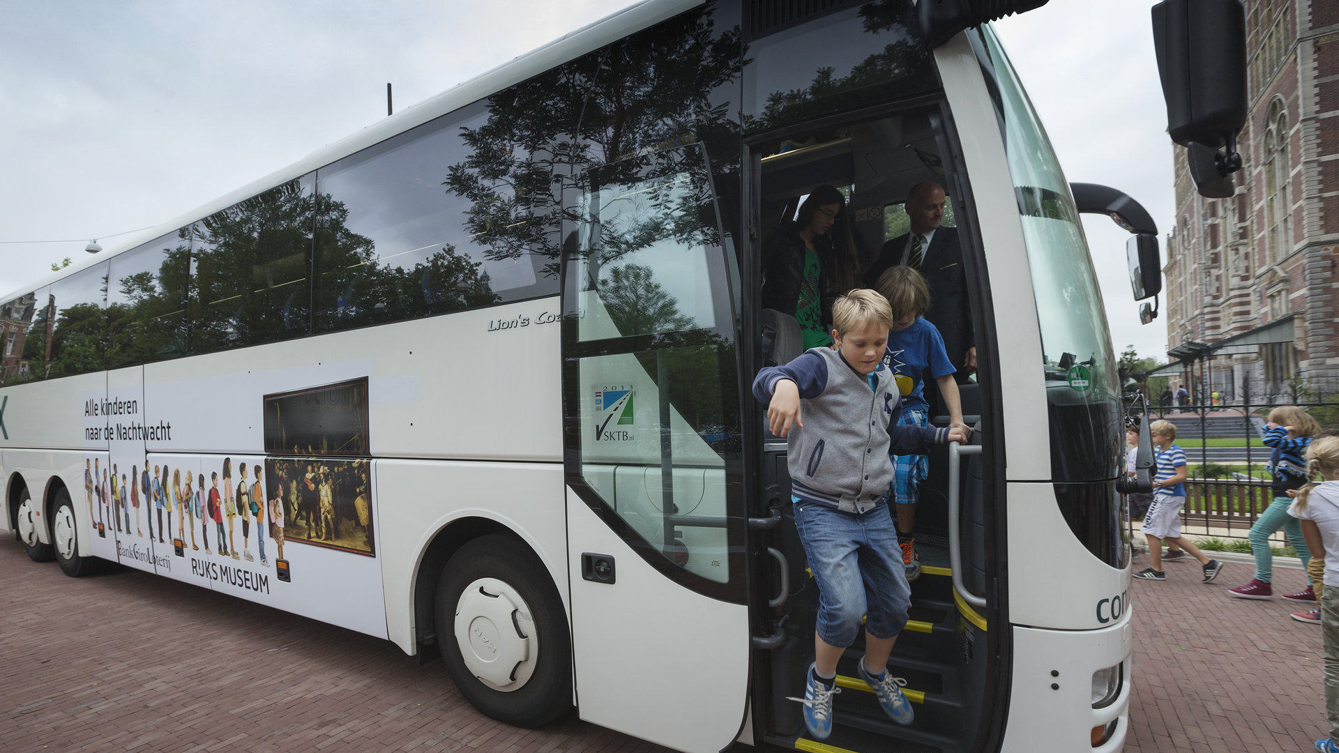 Een kind stapt uit de Rijksmuseumbus