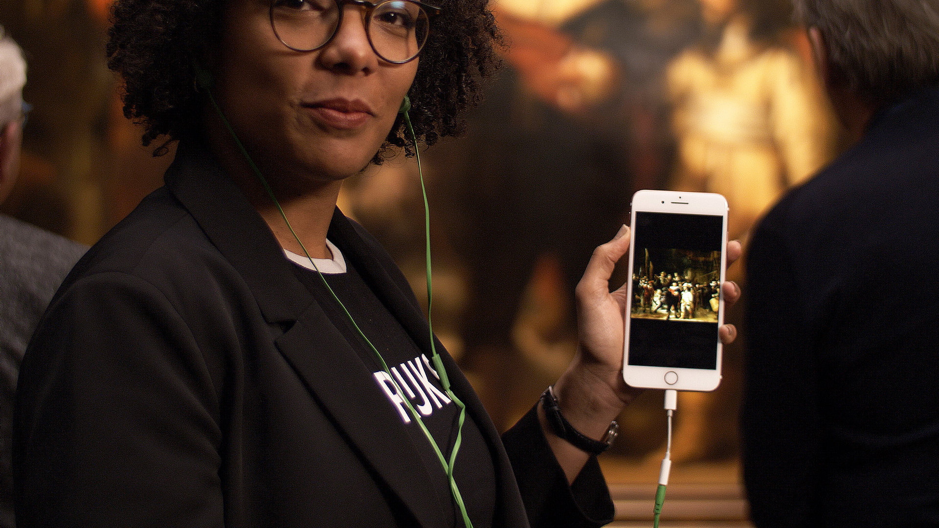 Een dame die de Rijksmuseum app op haar telefoon laat zien